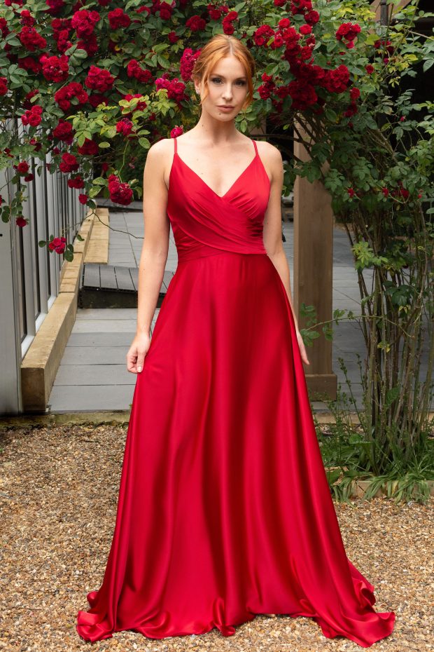 A bridesmaid in a red satin gown with a ruched V-neck bodice and a full A-line skirt
