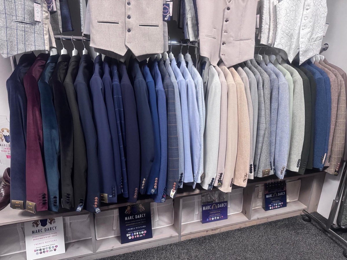 A rail of wedding suit jackets to buy in store